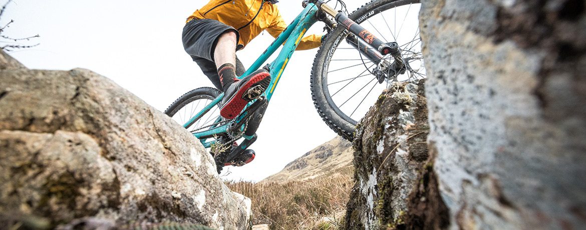 Mountain Biker riding a water bar in Torridon, Scotland, part of our How To Ride a Scottish Water Bar blog.